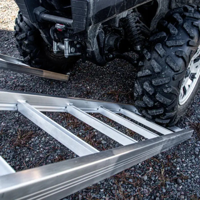 close up view of ATV tires at the ground and starting to climb on the aluminum ramps