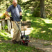 Man Clearing the pathway curb using cultivator edger