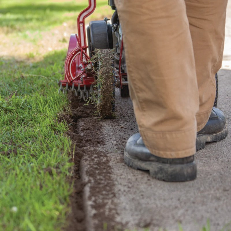 Rear View Of a Man Clearing The driveway using Earthquake Walk Behind Lawn Edger