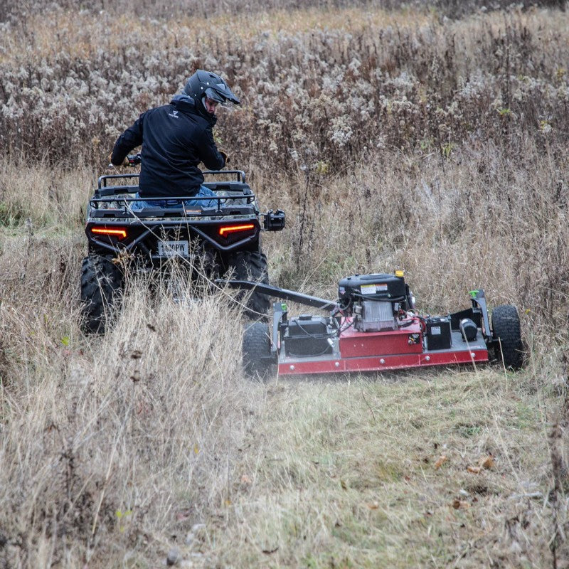 Rear View of Earthquake Acreage Tow Behind Rough Cut Mower Mounted On ATV in tall grass field