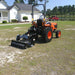 Man riding on his tractor with the standard roller attachment installed on UA40 aera vator