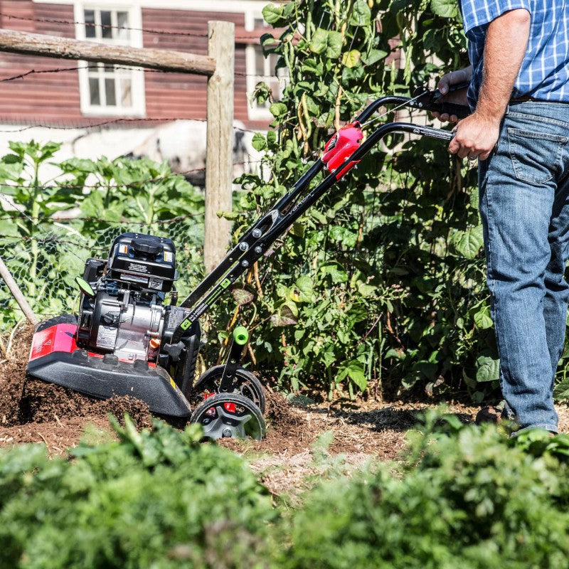 close up image of man using Earthquake Versa 2 in 1 Front Tine Tiller Cultivator in the garden with soil being broken