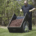 man dumping mulch from his garden cart