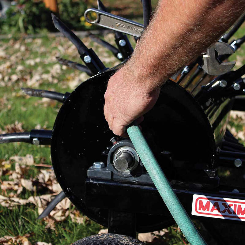 hairy hand holding a water hose and refilling the Maxim tow behind aerator rear view of 48 Inch Maxim tow behind aerator