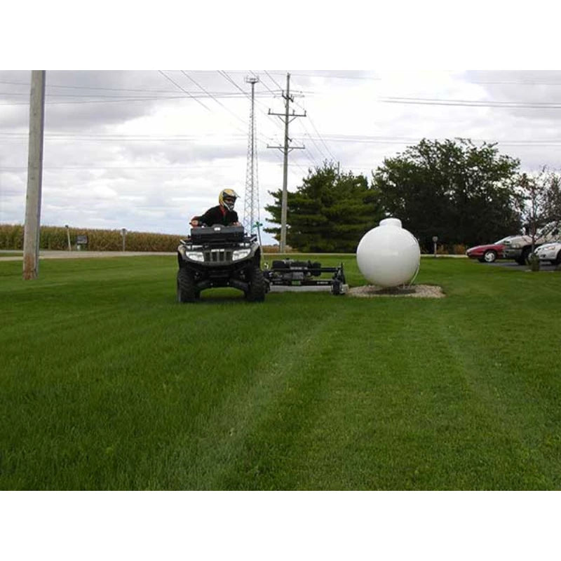 Man driving his ATV with Kunz Engineering 60 in. AcrEase Finish Cut  Wing Mower Model Pro60B pulled by it