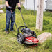 man clearing lawn using 160cc Earthquake Walk Behind String Mower