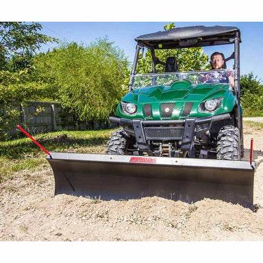 front view of a man driving his green UTV with front view of Swisher 62" UTV Commercial Pro Plow mounted on it