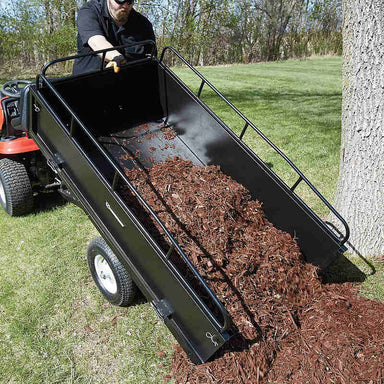 man dumping tree barks from his trailer