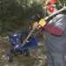 man holding a branch on his both hands while feeding it to the Powerhorse Rotor Wood Chipper 