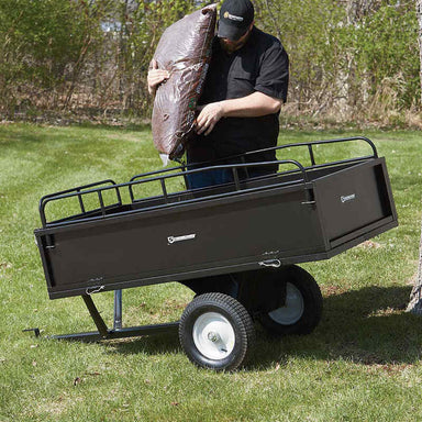man loading a fertilizer into his ATV trailer