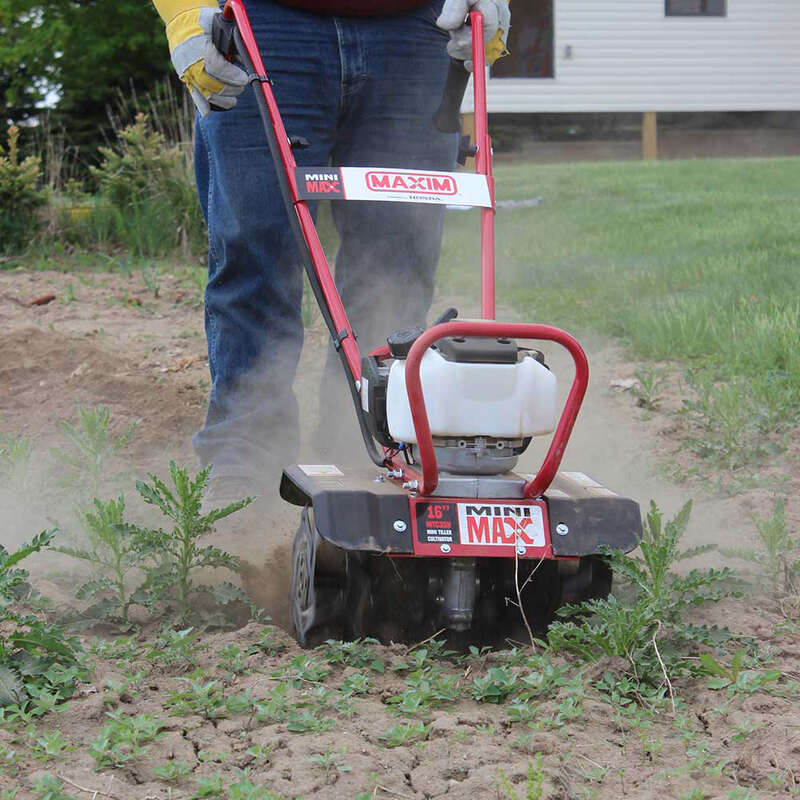 man tilling his garden using the maxim mini max tiller 