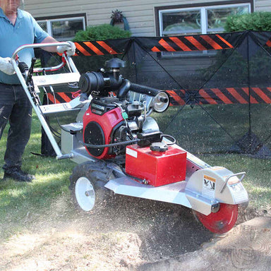 man operating the  Dosko 20 HP Self Propelled Stump Grinder and grinding the tree stump