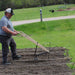 man plowing his garden using the high wheel plow