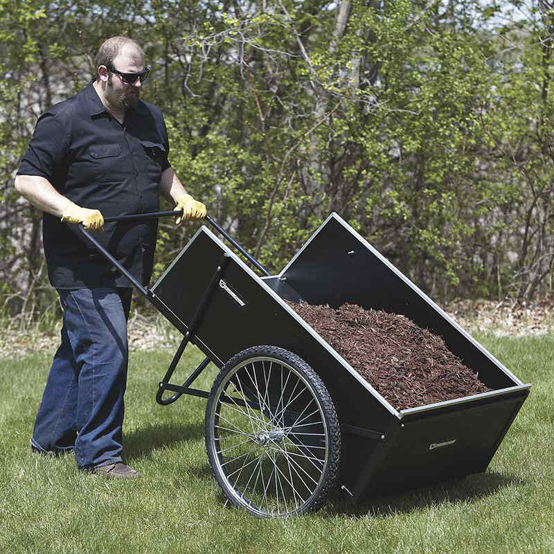 man pushing his garden cart full of tree chips