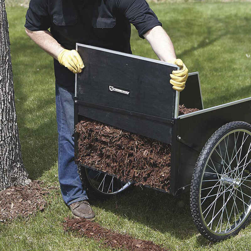 man removing the rear panel of his garden cart