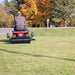 rear view of a man riding in red toro lawn mower with 36 inch tow behind aerator installed