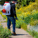 Man Spraying Pesticide using Tomahawk Power 5 gal. Gas-Powered Backpack Sprayer with Twin Tip Noozle