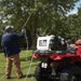 man spraying water on the tree leaves with the closed up view of  NorthStar ATV boomless broadcast and spot sprayer nozzle with high pressured water coming out mounted on ATV