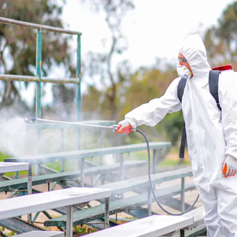 Man Wearing a full PPE while spraying a pestIcides