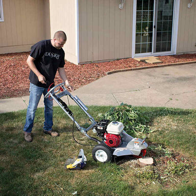 man grinding the tree stump with just one hand