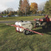 NorthStar Tow-behind Trailer Boom Broadcast and Spot Sprayer on the lawn with its boom arms spread out