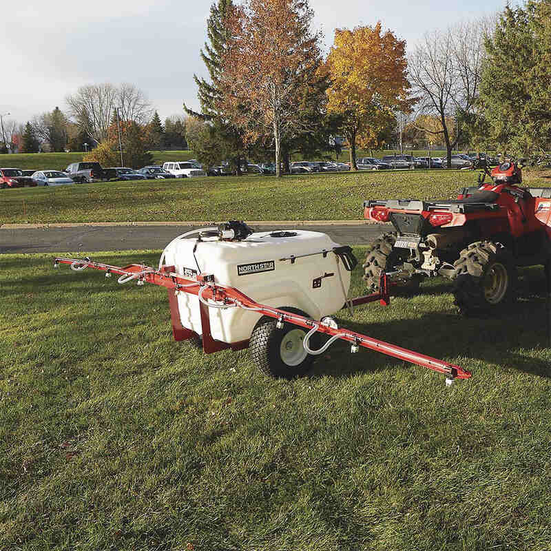NorthStar Tow-behind Trailer Boom Broadcast and Spot Sprayer on the lawn with its boom arms spread out