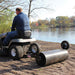 side view of a man driving his red lawn mower with 36 Inch spike aerator attach to it