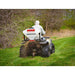 rear view of a man driving an ATV with plants seeds coming out from the swisher ATV spreader