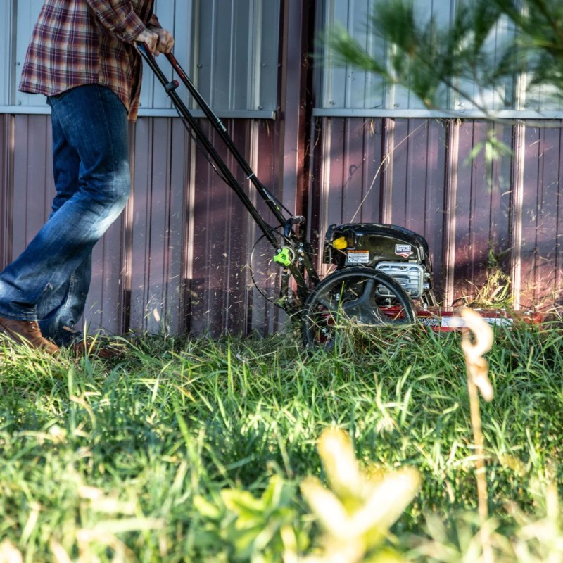 side view of 163cc earthquake walk behind string mower with briggs and stratton engine clearing lawn