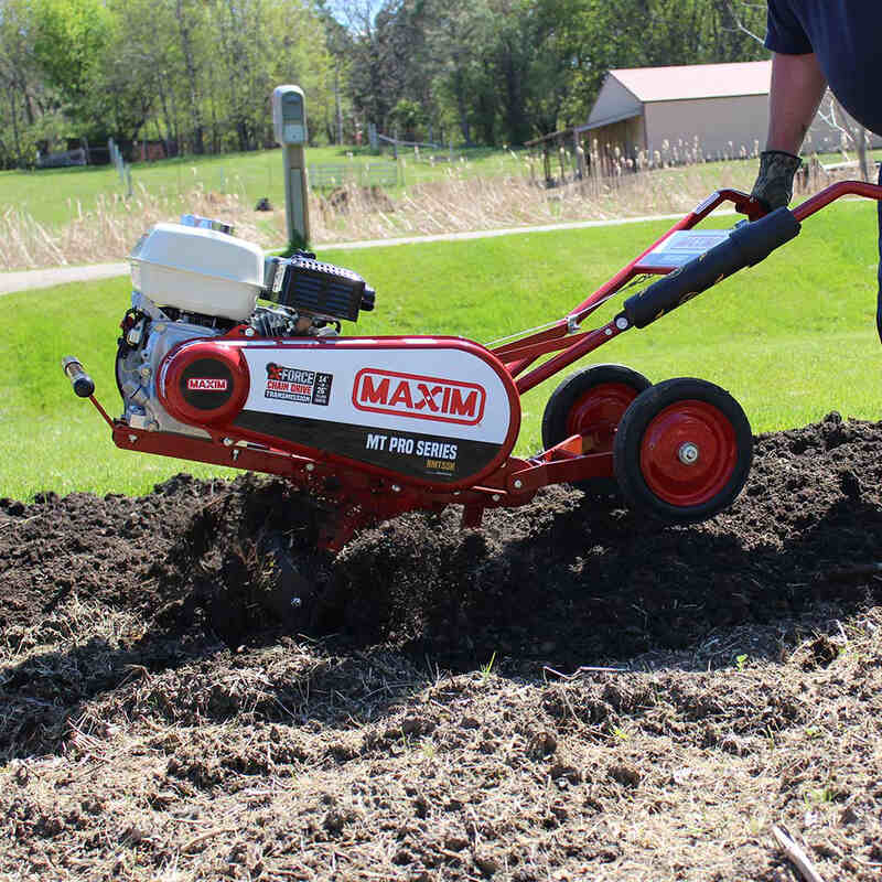side view of maxim commercial tiller with its blade covered with soil