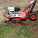 side view of maxim compact tiller with its tiller blade covered with soil