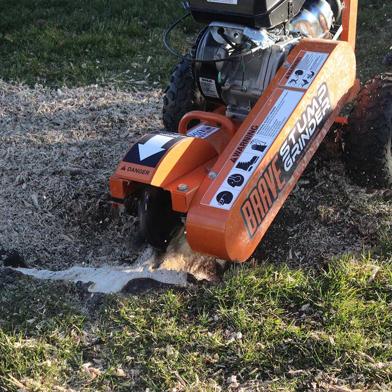 Brave Stump Grinder 14 HP Kohler walk-behind model grinding a stump near a home